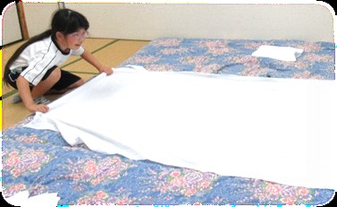 シーツを敷く児童