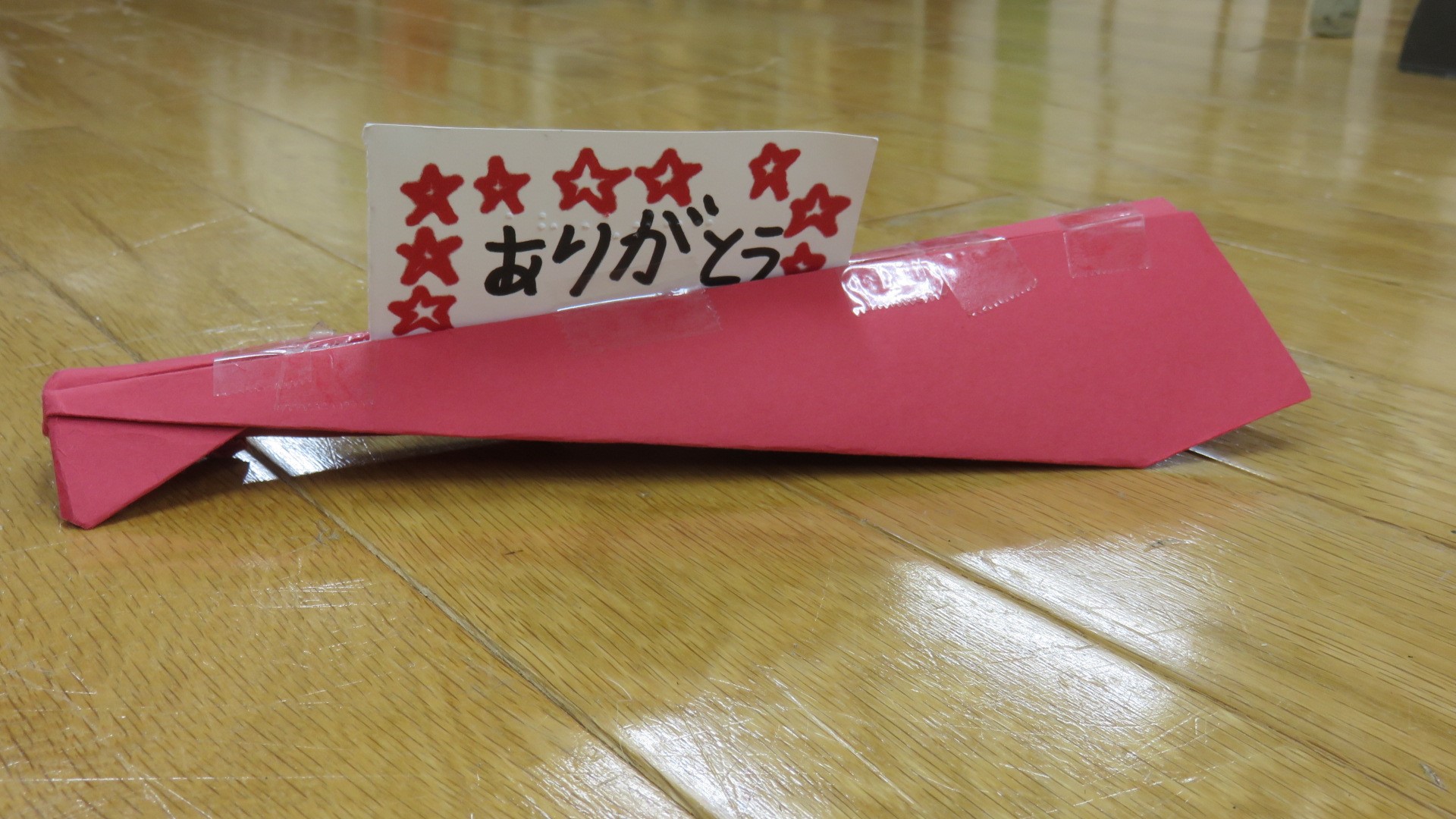 「ありがとう」と書いたメッセージを乗せた紙飛行機