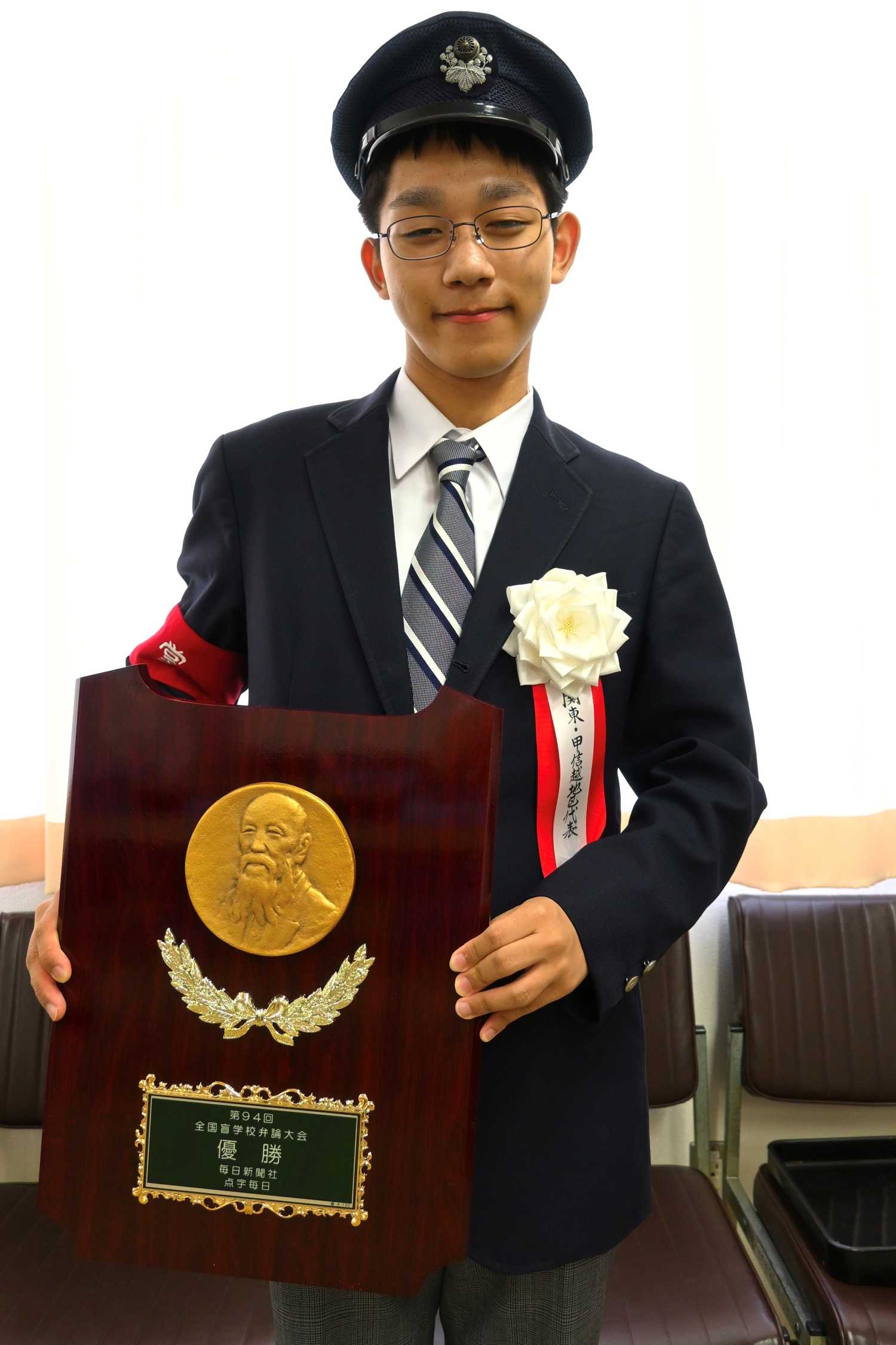 祖父の国鉄の帽子をかぶり優勝盾を持っている菅野さん