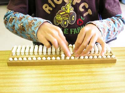 画像:盲人用そろばんを使って計算をしている子どもの写真