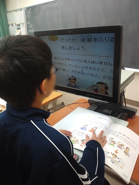 画像:拡大読書器を使って教科書を読んでいる子どもの写真