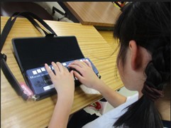画像:ブレイルメモを使用している子どもの写真